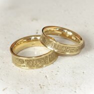 Handcrafted 14k yellow gold wedding rings with fingerprint engraving