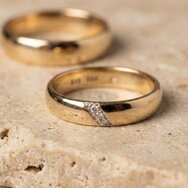 Handcrafted yellow gold wedding rings with classic diamond setting