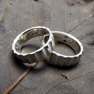 Handcrafted 925 sterling silver wedding rings with emeralds and sapphires set inside the bands