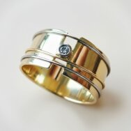 Handcrafted 14k yellow gold band ring with bezel-set diamond and polished details