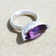 Handcrafted sterling silver ring with rough organic texture and violet marquise-cut amethyst