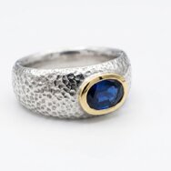 Handcrafted two-tone silver and gold ring with hammered texture and blue sapphire