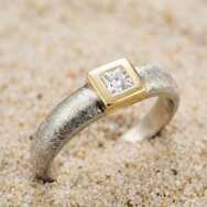Handcrafted white and yellow gold ring with princess-cut diamond and textured finish