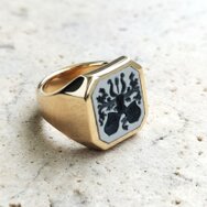 Handcrafted 18k yellow gold signet ring with dark layered stone and engraved family crest