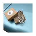 Sterling-Silber V8 Schlüsselanhänger in brauner Geschenkbox auf hellblauer Motorhaube – hochwertiges Geschenk für Classic-Car Liebhaber